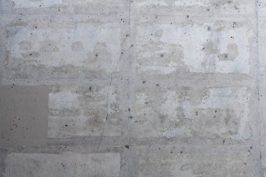 Ham, yamalı desenli ve gri renkli pürüzsüz beton bir duvarın yakın plan ayrıntıları.