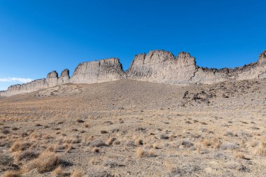 Shiprock, New Mexico yakınlarındaki yüksek çöl arazisinden kaya oluşumları yükseliyor..