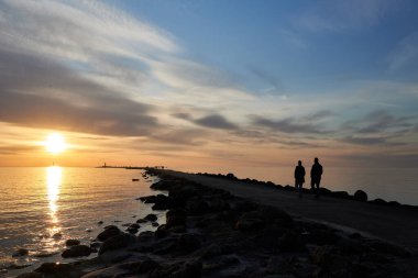 Akşam körfezi, deniz feneri ve gün batımı.