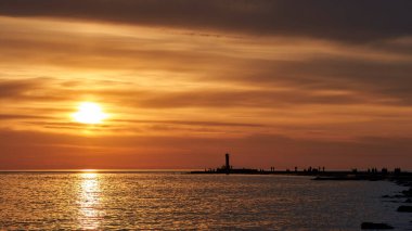 Akşam körfezi, deniz feneri ve gün batımı.