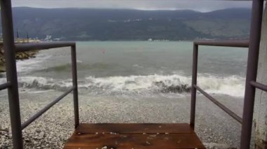 Küçük ahşap bir iskeleden deniz manzarası. Arka planda dağlar var..