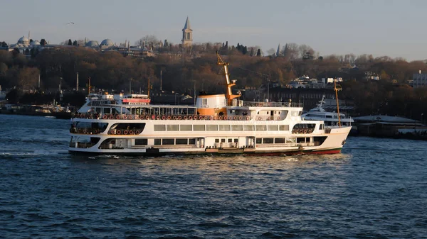 Bir yolcu feribotu gün batımında Boğaz 'da kıyıya yaklaşıyor.