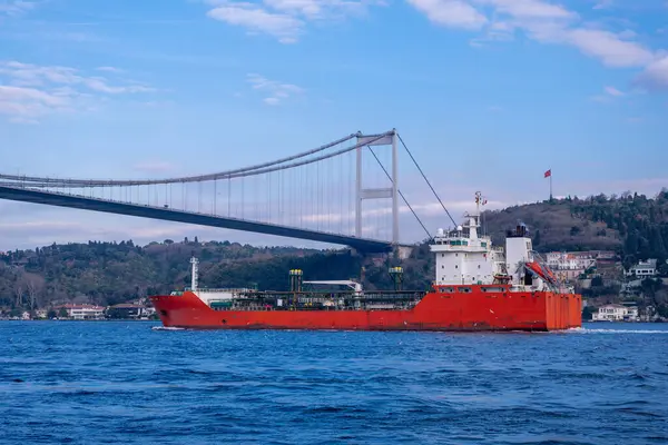 Boğaz 'daki Fatih Sultan Mehmet Köprüsü' nün altından geçen kırmızı bir tanker gemisi. Güzel İstanbul manzarası.