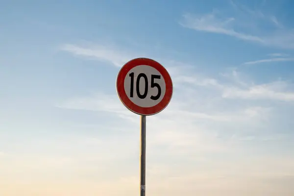 Günbatımı gökyüzü ile izole edilmiş maksimum hız sınırı levhası 105 km