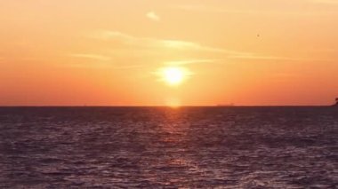 Deniz dalgasında gün batımı ufku