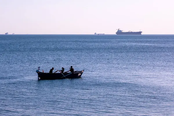 Sakin bir gölde kürek çeken üç kişi