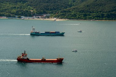 İki kargo tankeri ve bir yelkenli birbirlerini açık sularda geçiyor.