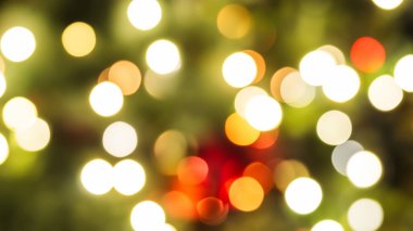 Soyut bokeh arkaplanı, kırmızı ve altın rengi yılbaşı ağacındaki noel ışıkları..