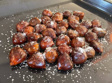 Taze kestaneler üzerine deniz tuzu serpiştirilmiş.