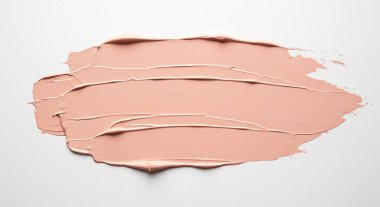 Beyaz arkaplanda pembe kozmetik krem ve fırça darbesi izole