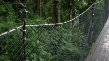 Rüzgarlı ortamda hareket eden bir halat ağından yapılmış asma köprü çiti. 