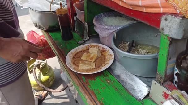 ケトパックを調理する 豆スプロット バーニチェッリ ケトパックは ジャカルタのインドネシアのベジタリアン料理で 米ケーキ ピーナッツソースで提供される米のバーベリで構成されています — ストック動画