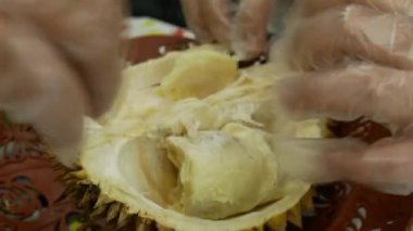 Durian meyvesini çıplak elle parçalayıp açmış.
