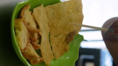 Pangsit Goreng Ayam 'ı ezmek, kızarmış tavuk köftesi ve domates sosuna batırmak. Endonezya sokak geleneksel yemekleri, Çin yemekleri.