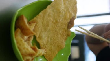 Endonezya Çin yemeği pangsit goreng ayam, yeşil tabakta kızarmış tavuk köftesi, dikey video