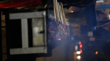 Endonezya usulü tavuk pişirme kömürü, yelpaze, bulanık duman ve dikey video kullanarak geleneksel yoldan