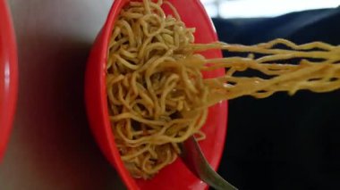 Bakmie ayam, tavuklu erişte, mie ayam, yemek çubuğuyla Endonezya Çin yemeği yemek. dikey video
