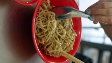 Bakmie Ayam, tavuklu erişte, mie ayam, Endonezya Çin yemeklerini çubukla karıştırmak. dikey video