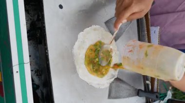 Martabak Telor veya omlet martabak. Yumurta, et ve baharatla doldurulmuş tuzlu tavada kızartılmış hamur işi. Endonezya 'dan geleneksel yiyecek atıştırmalıkları, dikey