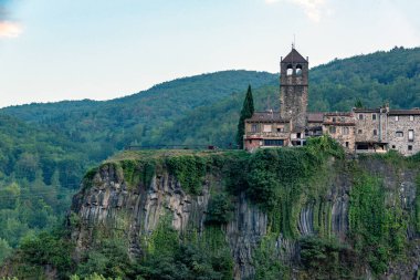 Castellfollit de la Roca, üstüste binen iki lav akıntısının oluşturduğu bazaltik bir duvarda yer almaktadır.