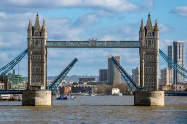 Londra 'daki Kule Köprüsü bulutlu bir gökyüzü ve kentsel arkaplan altında görünürde hiçbir gemi olmadan tamamen yükseltildi..
