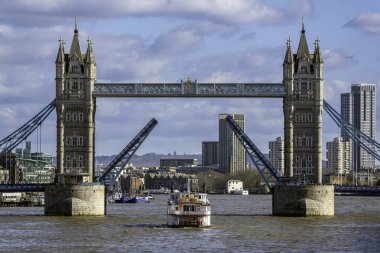 Londra 'daki Tower Köprüsü arkaplanda şehrin ufuk çizgisi olan bir teknenin geçmesine izin vermek için açılıyor..
