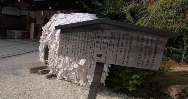 许多希望摆脱不良关系的神圣卡片都贴在神龛上 一块有着神秘灵性力量的大石头日本京都的神龛 — 图库视频影像