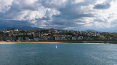 Güneşli bir günde sahile ulaşan yelkenli.