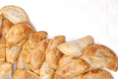 Ev yapımı börekler tavuk eti sebze, jambon ve peynirli ahşap tabakta sos ve limonla pişiriliyor. 