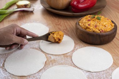 Hamurla çiğ ev yapımı börek yapma ve elleri birleştirme ve börekleri sebzelerle doldurma tavuk eti, jambon ve peynir ile doldurma ve repulgue yapma süreci. 