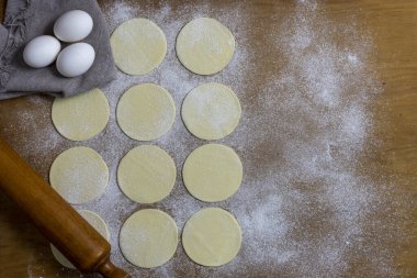 Hamurla çiğ ev yapımı börek yapma ve elleri birleştirme ve börekleri sebzelerle doldurma tavuk eti, jambon ve peynir ile doldurma ve repulgue yapma süreci. 