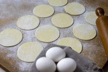 Hamurla çiğ ev yapımı börek yapma ve elleri birleştirme ve börekleri sebzelerle doldurma tavuk eti, jambon ve peynir ile doldurma ve repulgue yapma süreci. 