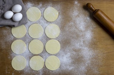 Hamurla çiğ ev yapımı börek yapma ve elleri birleştirme ve börekleri sebzelerle doldurma tavuk eti, jambon ve peynir ile doldurma ve repulgue yapma süreci. 