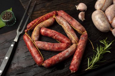 Achuras ve sosis ve domuz sucuğu sucuk sucuk sucuk sucuk bonbon ahşap tahta üzerinde sos ve sebze 