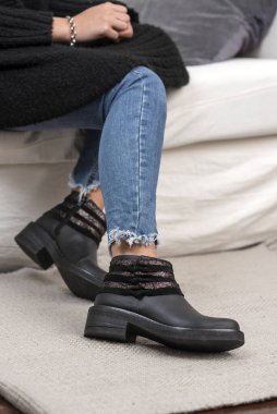 Farklı renklerde deri modellerden, kot, elbise ve taytlardan oluşan şık ayakkabıları olan kadın bacakları. 