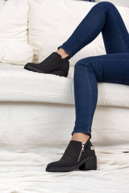 Farklı renklerde deri modellerden, kot, elbise ve taytlardan oluşan şık ayakkabıları olan kadın bacakları. 