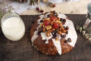 tatlı ekmek ve Noel ve bayram pudingleri fındıklı ve jöleli meyveler, bütün ve dilimlenmiş badem ve kestaneler beyaz masada. 