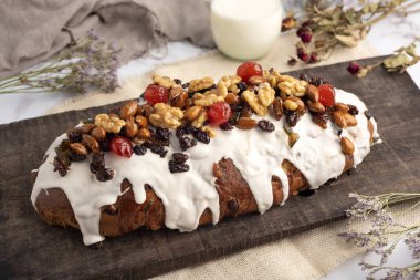 tatlı ekmek ve Noel ve bayram pudingleri fındıklı ve jöleli meyveler, bütün ve dilimlenmiş badem ve kestaneler beyaz masada. 