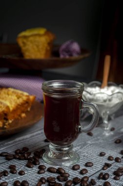 Kahvaltı ya da atıştırmalık bir fincan kahve ve taze kahve çekirdekli kahve makinesi tatlı kurabiyeler çikolata ve çeşitli kekler. 