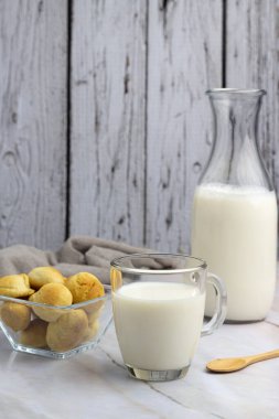Kahvaltı ya da aperatif olarak bir bardak sütlü çay ile alfajore Madeleines tatlı kurabiyeler çikolata taze meyveler ve çeşitli kekler. 