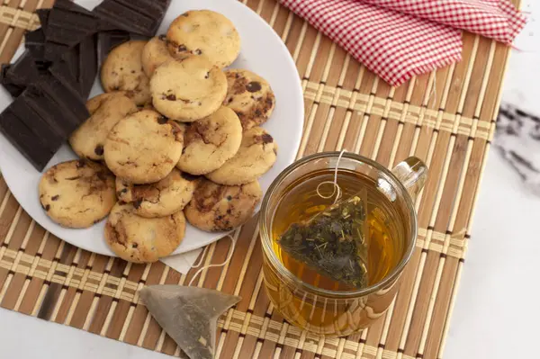 Kahvaltı ya da aperatif olarak bir bardak sütlü çay ile alfajore Madeleines tatlı kurabiyeler çikolata taze meyveler ve çeşitli kekler. 