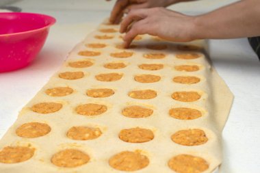 Sorentinoları doldurmak için ev yapımı makarna eller yapmak ve hamur kalıplarını mutfaktaki dolgu malzemeleriyle genişletmek. 