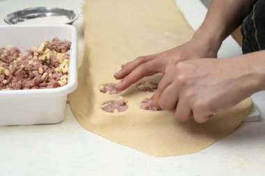 Sorentinoları doldurmak için ev yapımı makarna eller yapmak ve hamur kalıplarını mutfaktaki dolgu malzemeleriyle genişletmek. 