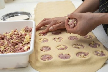 Sorentinoları doldurmak için ev yapımı makarna eller yapmak ve hamur kalıplarını mutfaktaki dolgu malzemeleriyle genişletmek. 