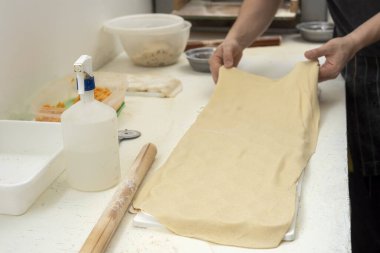 Sorentinoları doldurmak için ev yapımı makarna eller yapmak ve hamur kalıplarını mutfaktaki dolgu malzemeleriyle genişletmek. 