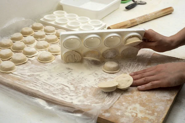 stock image making homemade pasta hands filling the sorrentinos and stretching the dough into molds with the filling in a kitchen 