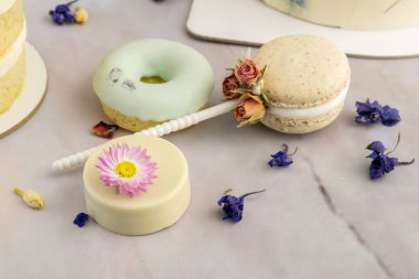 Kurutulmuş doğal çiçeklerle süslenmiş, çikolata soslu kurabiyeler, çörekler ve kekler. 