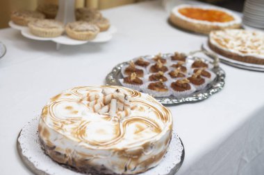 Pastalar meyveler ve şişler doğum günü için ve düğün kutlamaları tatlı yemek ve tatlı masasında süslemeli doğal çiçekler çikolatalı taze meyveler masanın üzerinde masa örtüsü ile  