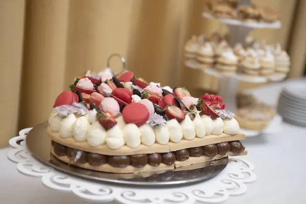 cake and pastries for birthday and wedding celebrations with decorations natural flowers cream chocolate fresh fruits on elegant table with tablecloth
