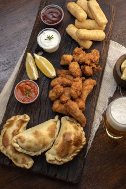 Masa ve tabakta Tequeo Gıda börekleri ve soslu nugget ve açık büfe yemekleri için patates ve peynir. 